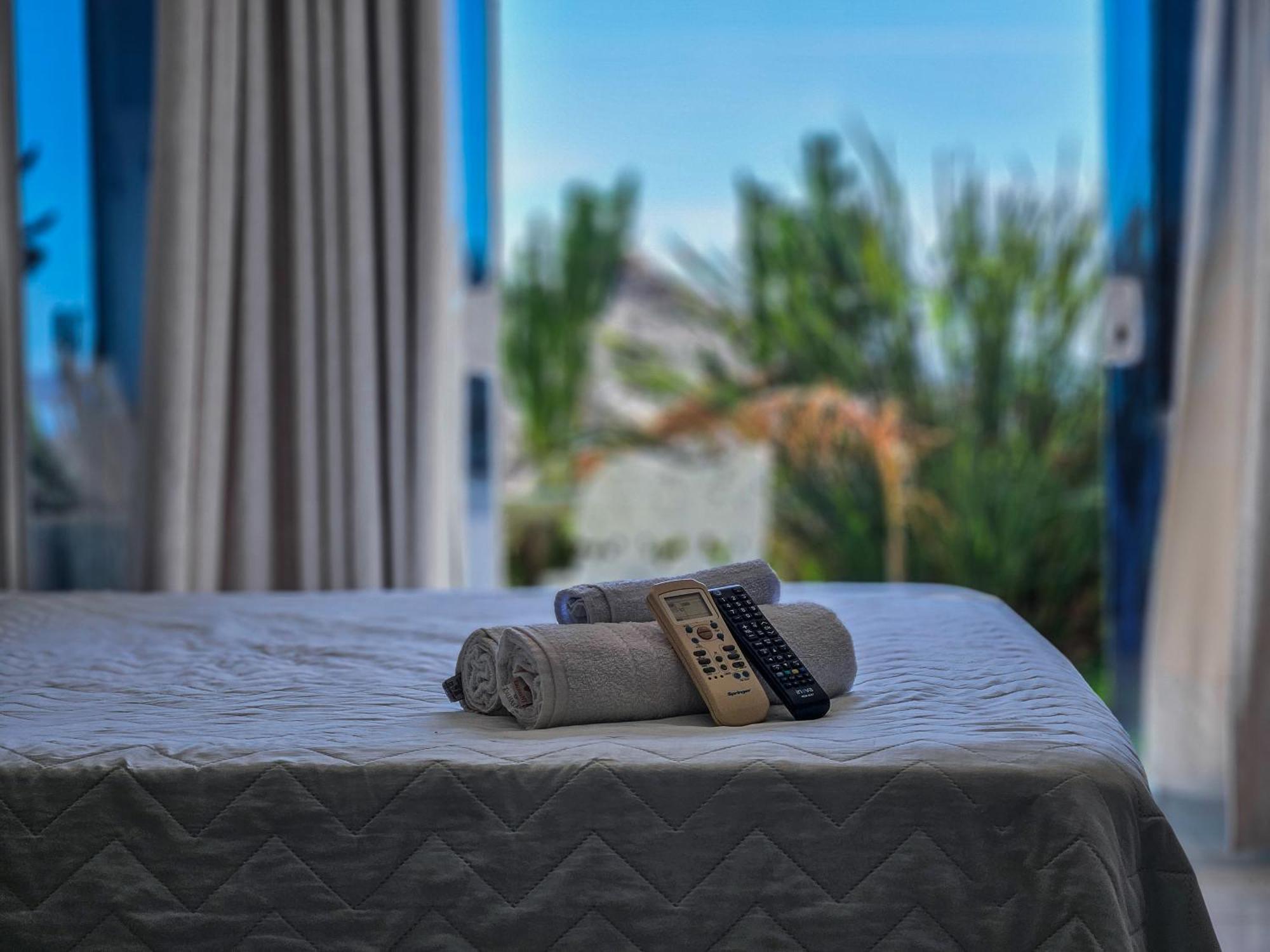 Bella Vista Ocean View Hotel Armacao dos Buzios Exterior photo A bed with a remote control and a towel